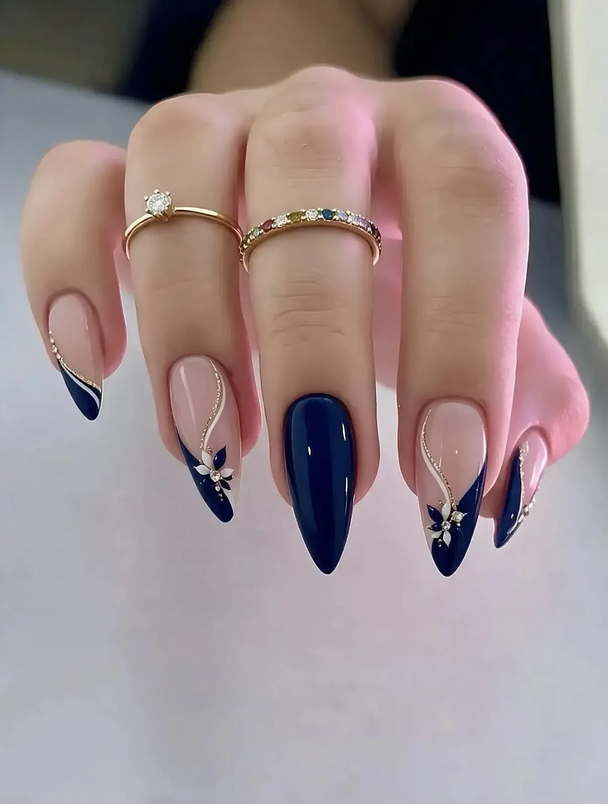 Dark nails with a small 3D spider charm on one accent nail